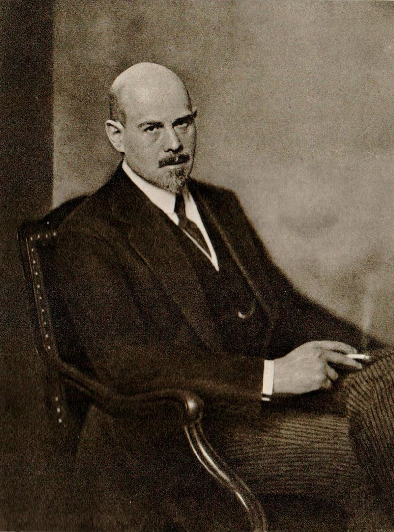 Schwarz-weiß-Foto von Walther Rathenau: Er sitzt Zigarette rauchend auf einem Stuhl mit Armlehne 